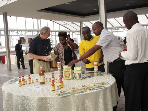Bernard O’Connell (left), Market Linked Programme Implementation Manager, and Anatole Habimana (in yellow), SOSOMA’s sales & Marketing Manager, showcase some of the selected Rwanda’s SOSOMA products to the participants during the sales mission’s informal Networking Event that gathered Rwanda sellers and Ugandan potential buyers on March 4th 2014 in Kololo Courts Hotel, Kampala, Uganda. TradeMark Africa (TMA) has funded a sales mission of selected Rwandan companies to Kampala in March 2014 as part of its support to Rwanda Development Board’s Export Promotion Programme aiming at boosting Rwanda’s exports to the EAC.