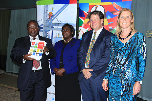 Minister Works and Transport John Byabagambi, Ms. Edith Mwanje Permanent Secretary Ministry of East African Community Affairs, Frank Matsaert CEO Trade Mark East Africa and Karin Anderson Programme Chair Investment Committee Trade Mark East Africa pose for a photo during the official hand over of the 2013/2014 TMA Annual Report to the Ugandan Government in Kampala